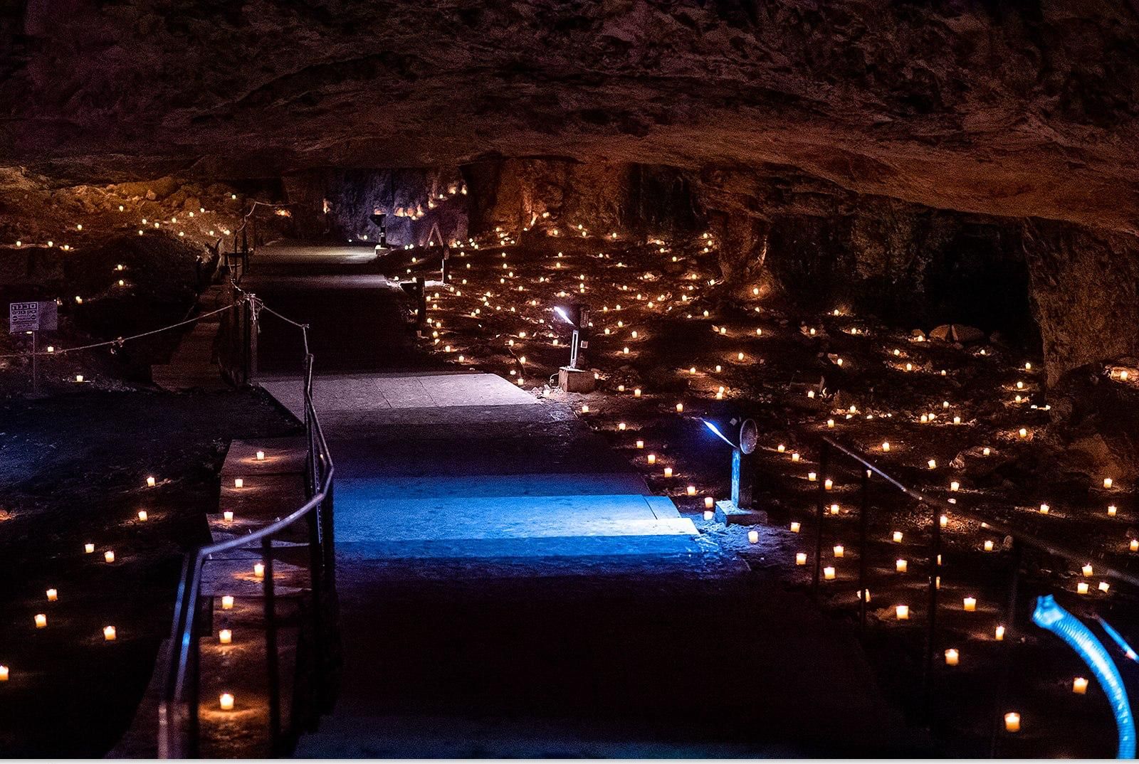 A candle-lined path leading into the cave