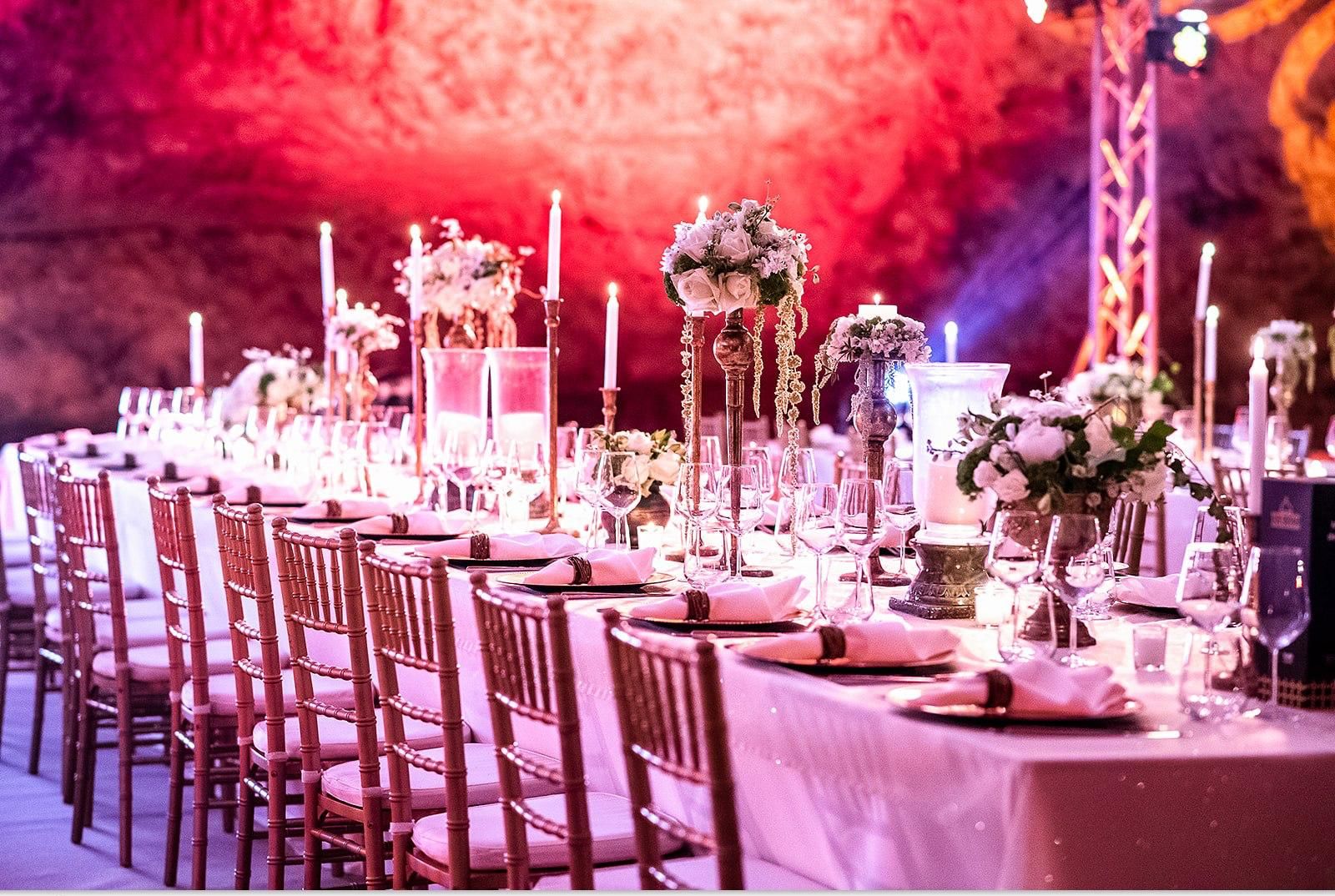 The set table under red light against the cave wall