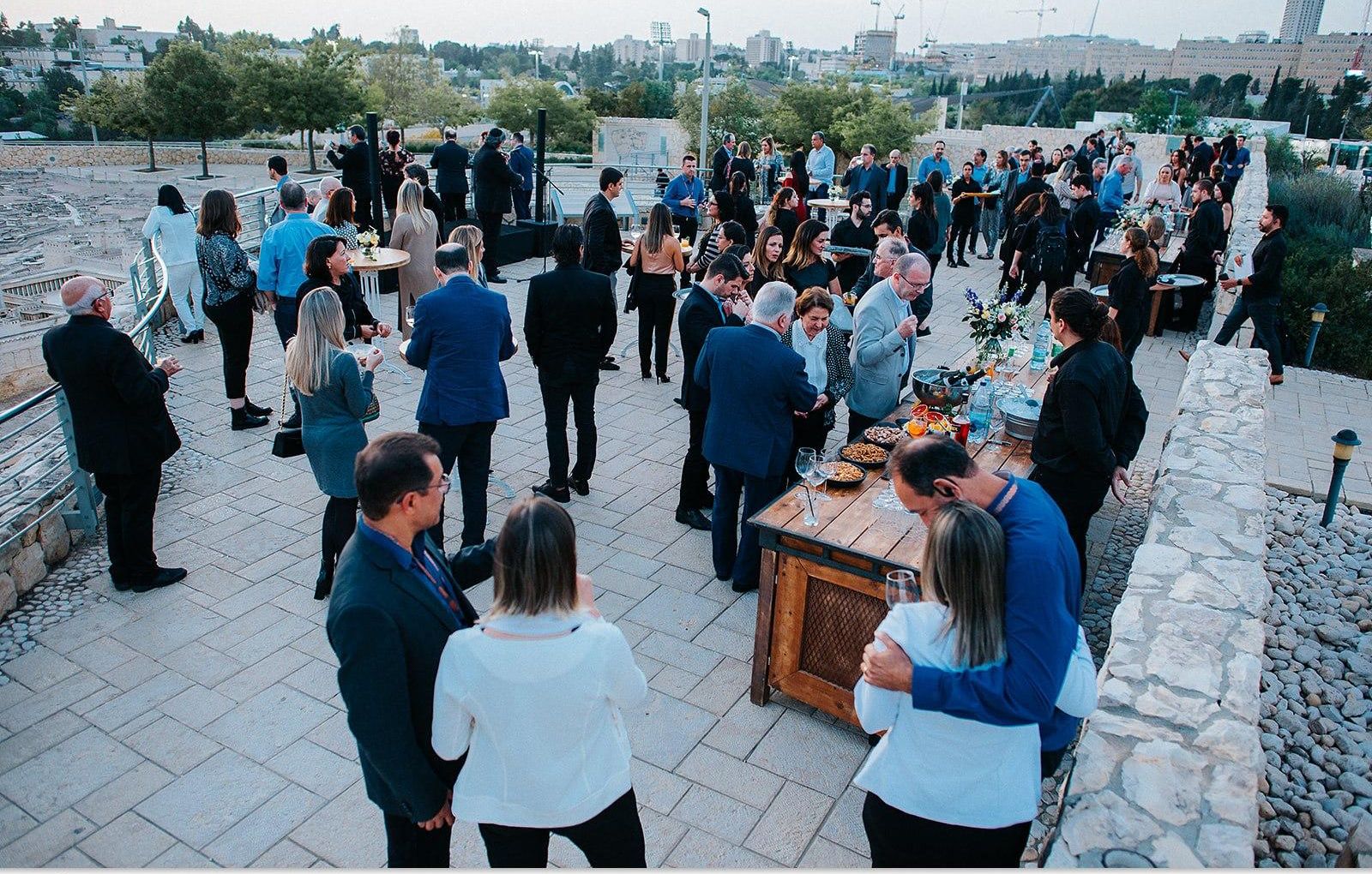 Guests at a rooftop reception above Jerusalem at dusk