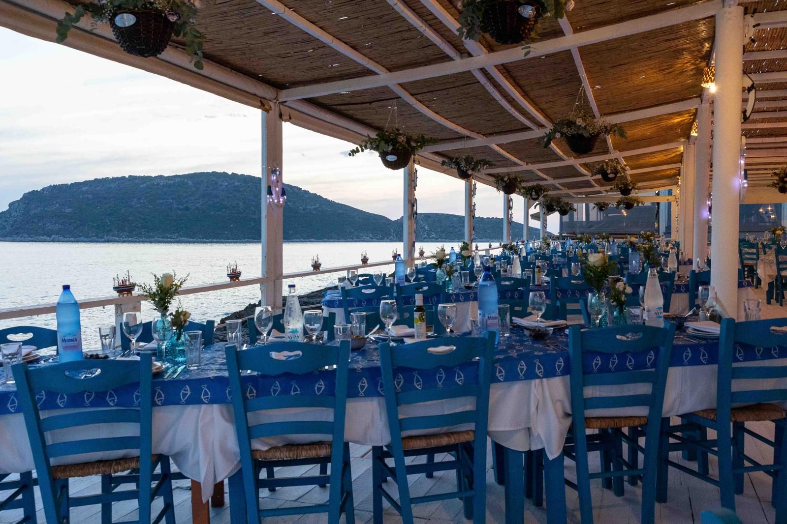 Long blue tables on the terrace with the island behind